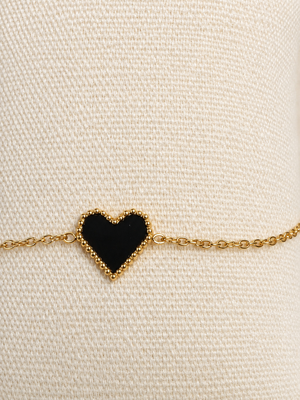 Bracelet doré avec cœur noir bordé de perles