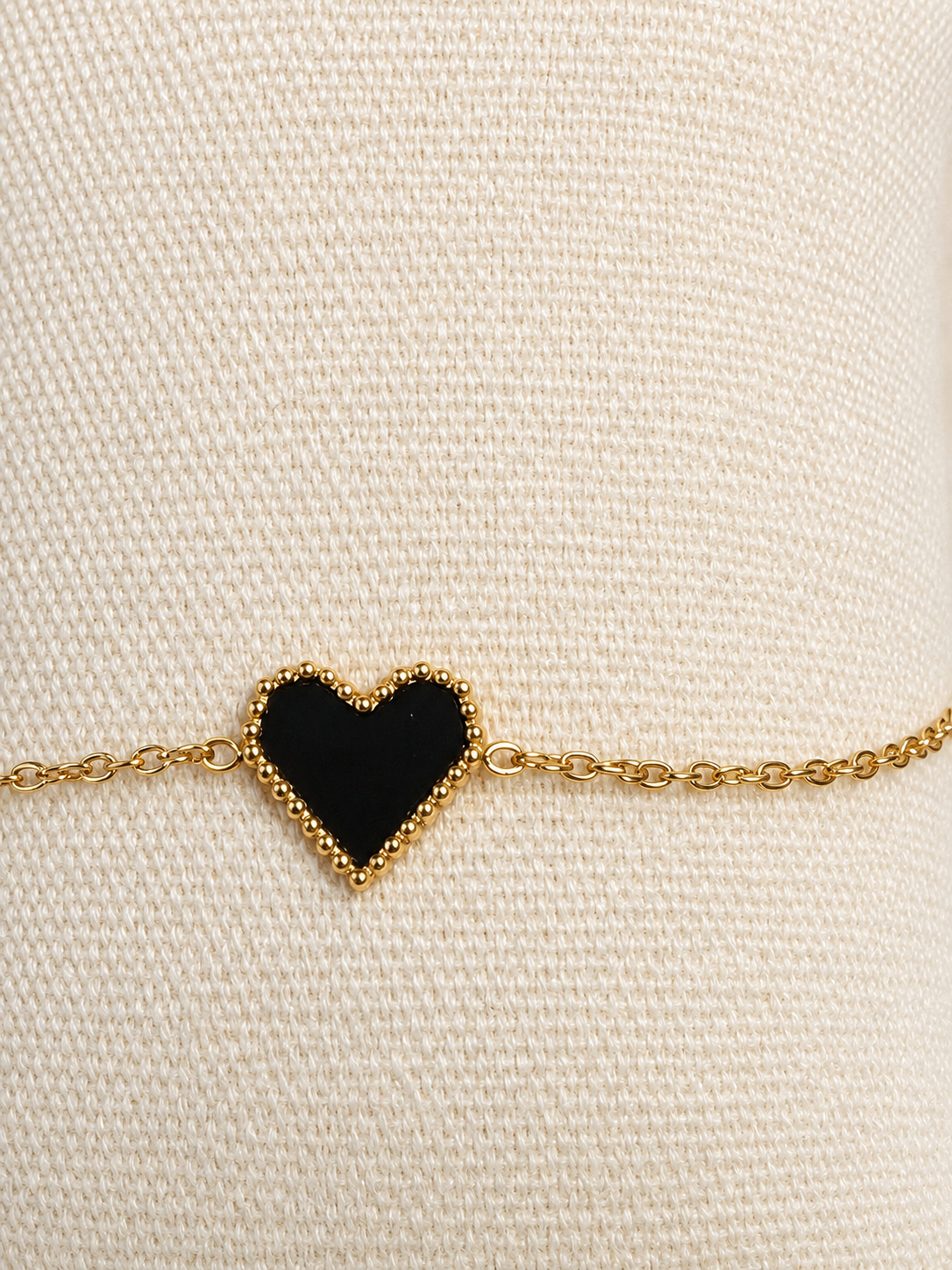 Bracelet doré avec cœur noir bordé de perles