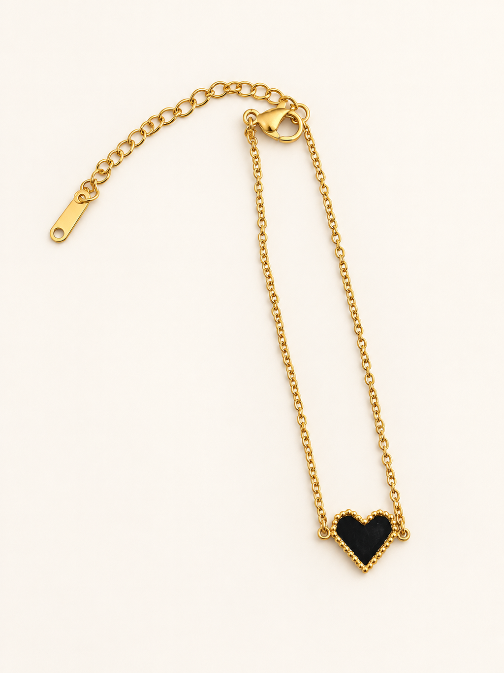 Bracelet doré avec cœur noir bordé de perles